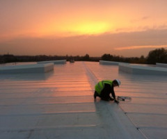 Man fixing a roof, sunset in the background Direct Strike earthing system repair in West Lothian